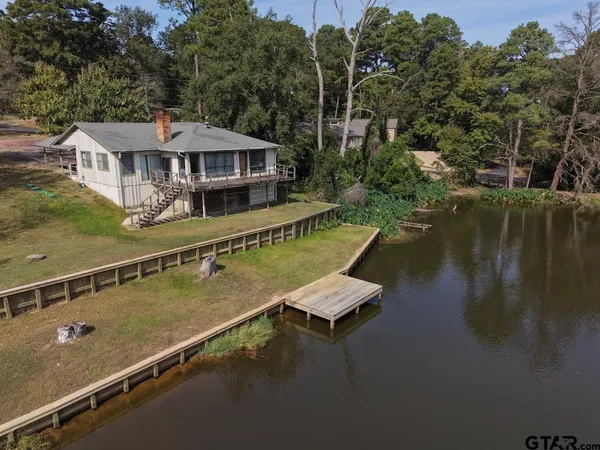 an aerial view of a house with swimming pool and outdoor seating