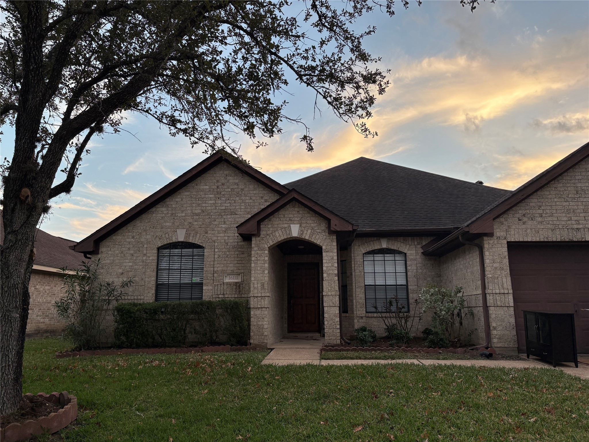a front view of a house with a garden and yard
