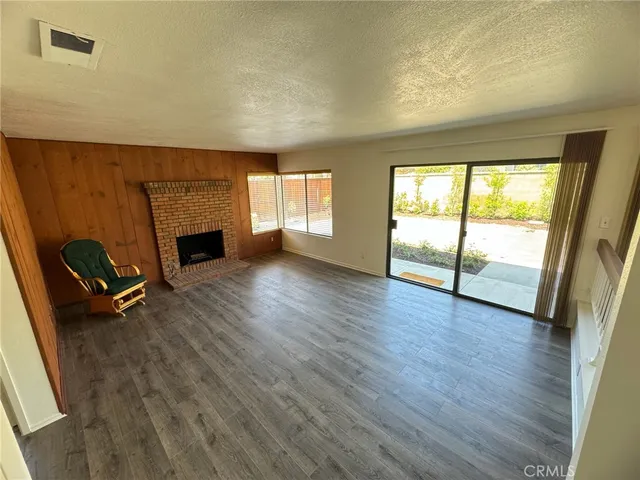 a view of empty room with wooden floor and fireplace