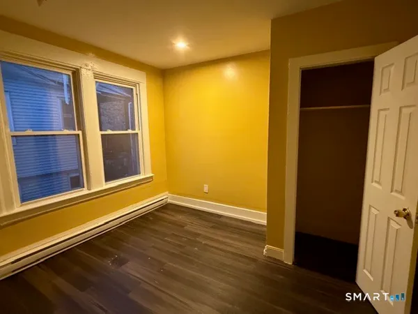 an empty room with wooden floor and entrance