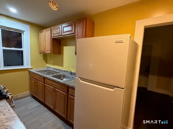 a kitchen with stainless steel appliances granite countertop a refrigerator and a stove
