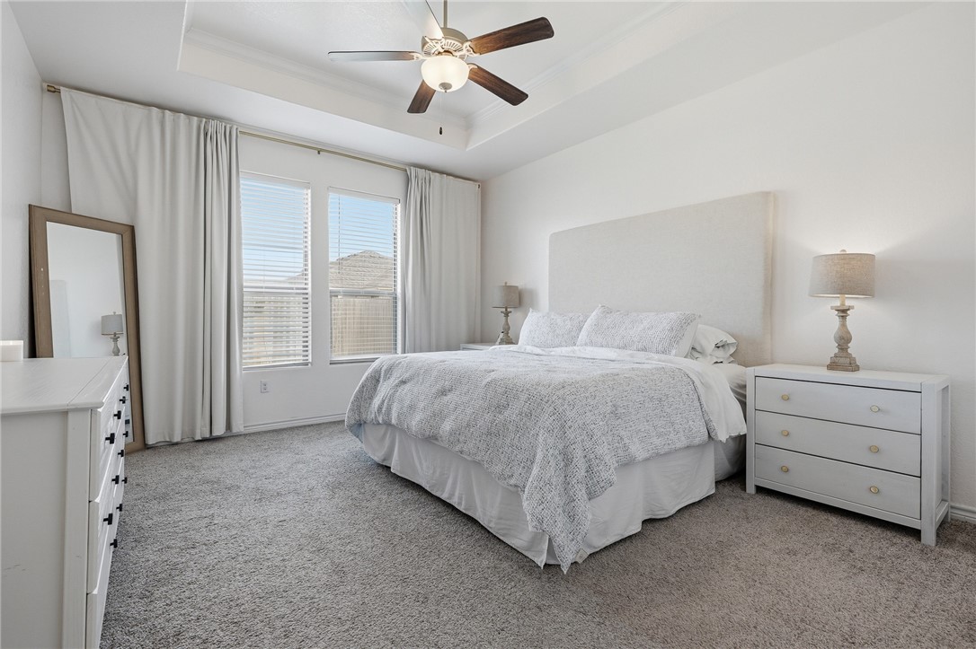 1026 Pasadena Street Portland, TX 78374 - Photo 18 of 30 a spacious bedroom with a bed and a chandelier