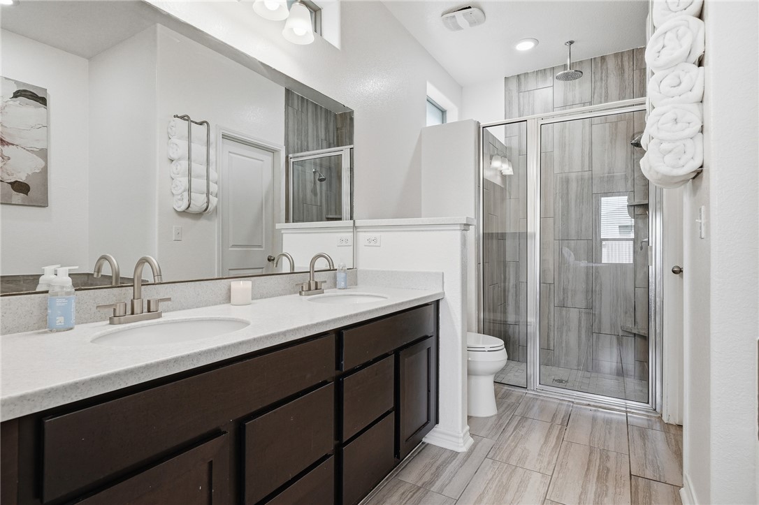 1026 Pasadena Street Portland, TX 78374 - Photo 20 of 30 a bathroom with a double vanity sink toilet and shower