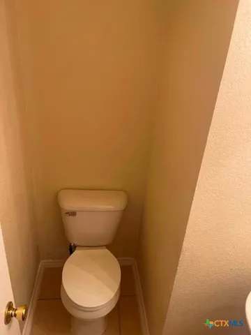 a white toilet sitting next to a white wall