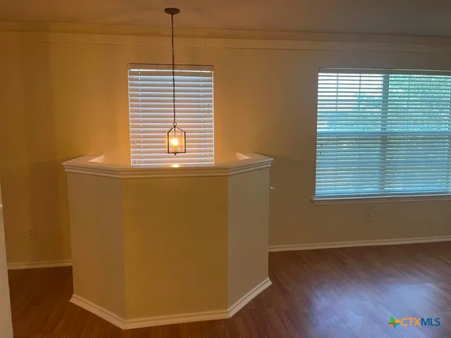 a view of a room with wooden floor and a window
