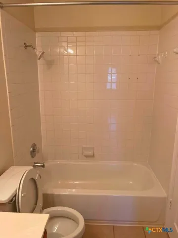 a bathroom with a tub a toilet and a shower