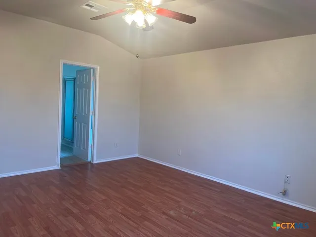 a view of an empty room with wooden floor