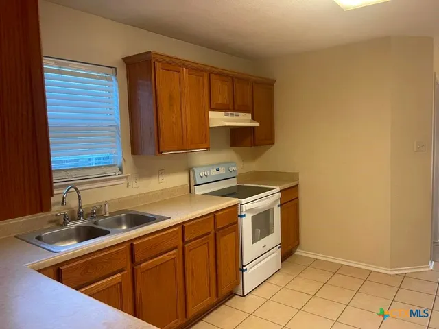 a kitchen with stainless steel appliances granite countertop a sink stove and cabinets