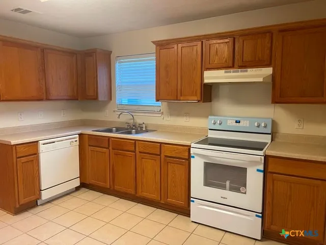 a kitchen with a sink stove and cabinets