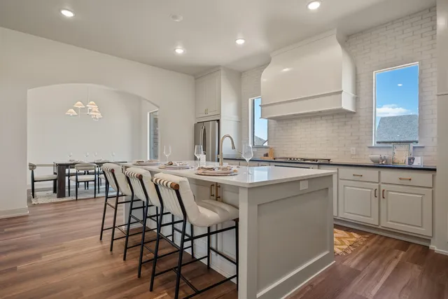 a kitchen with granite countertop white cabinets and stainless steel appliances