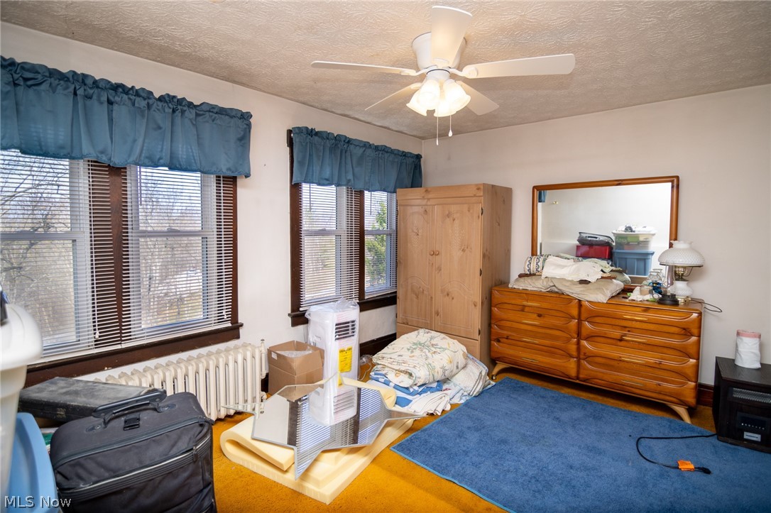 53341 Key Bellaire Road Bellaire, OH 43906 - Photo 27 of 48 Bedroom with radiator, ceiling fan, and a textured ceiling