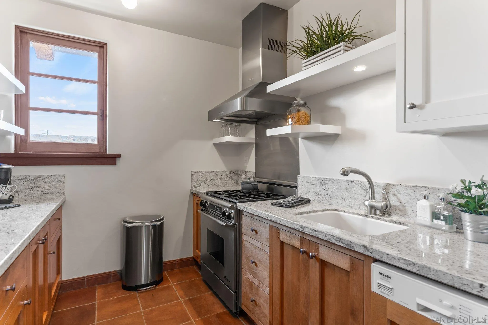 3113 Camino Del Rancho Encinitas, CA 92024 - Photo 24 of 40 a kitchen with stainless steel appliances granite countertop a sink a stove and a wooden floor