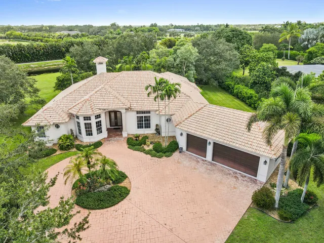 a aerial view of a house with yard and green space
