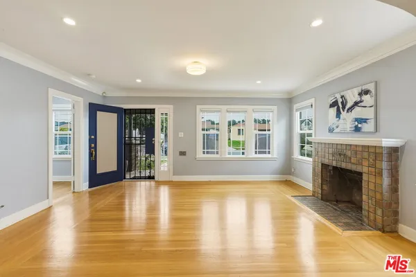 a view of an empty room with a fireplace and a window