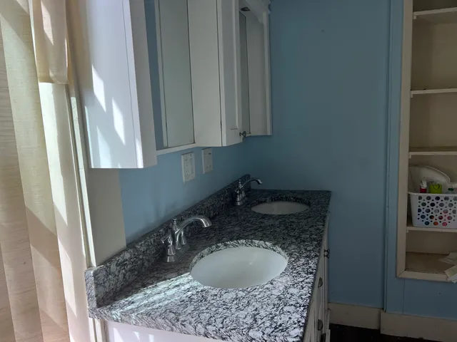 a bathroom with a granite countertop sink and a mirror