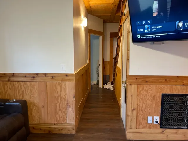 a view of a hallway with wooden floor and staircase
