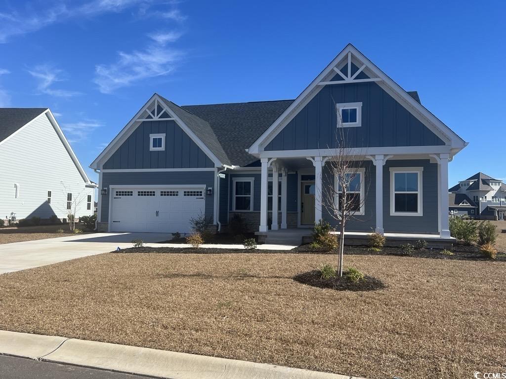 7031 Denim Loop Myrtle Beach, SC 29579 - Photo 1 of 28 View of front of property with board and batten siding, a porch, concrete driveway, a garage, and a front lawn