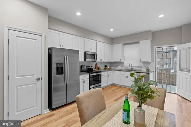 a kitchen with white cabinets and stainless steel appliances