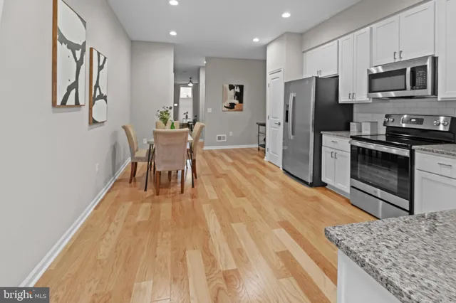 a kitchen with stainless steel appliances granite countertop a refrigerator stove microwave and sink