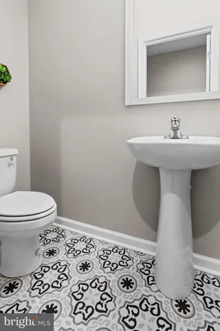 a bathroom with a sink toilet and mirror