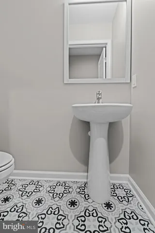 a bathroom with a sink a toilet and mirror