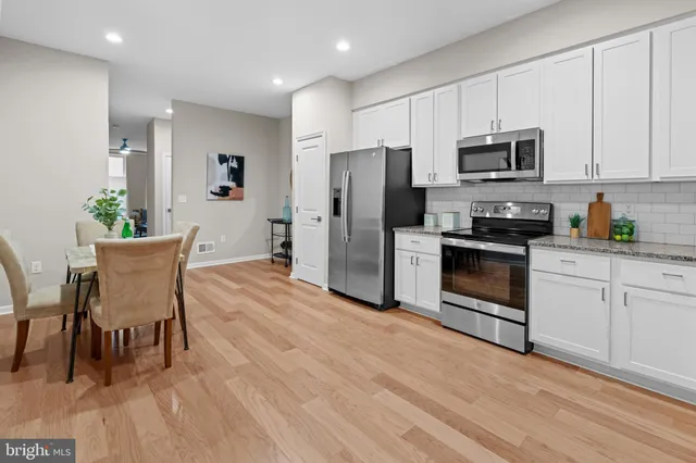 a kitchen with stainless steel appliances a stove a sink refrigerator and microwave