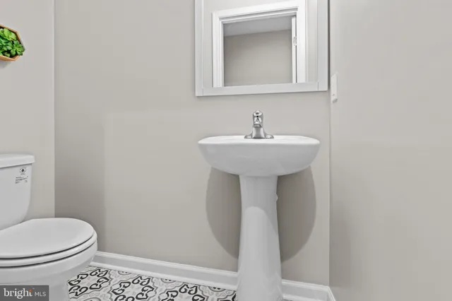 a bathroom with a sink toilet and a mirror