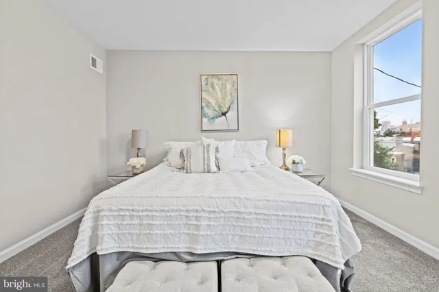 a bedroom with a bed and painting on the wall