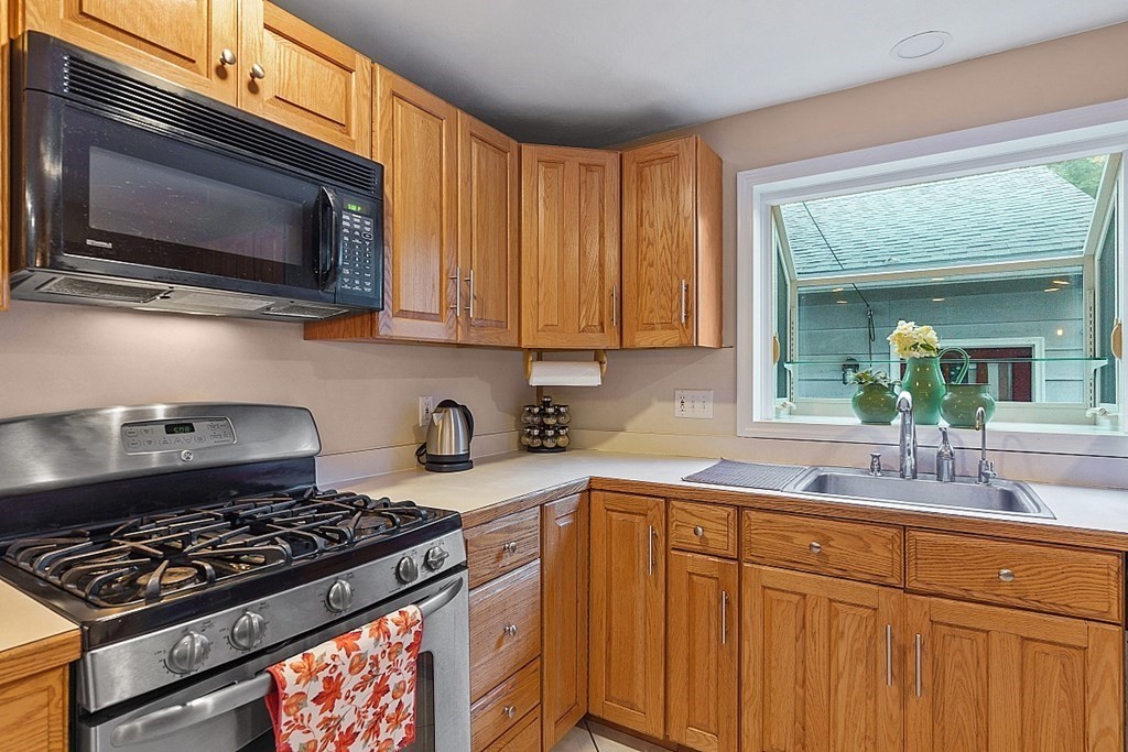 376 Littleton Road Chelmsford, MA 01824 - Photo 3 of 35 a kitchen with stainless steel appliances granite countertop a stove and a microwave