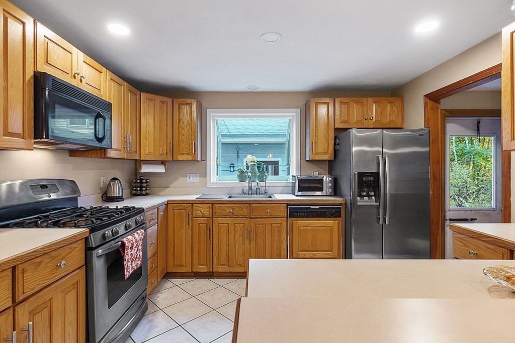 376 Littleton Road Chelmsford, MA 01824 - Photo 4 of 35 a kitchen with stainless steel appliances granite countertop a stove top oven a sink dishwasher a refrigerator and a microwave