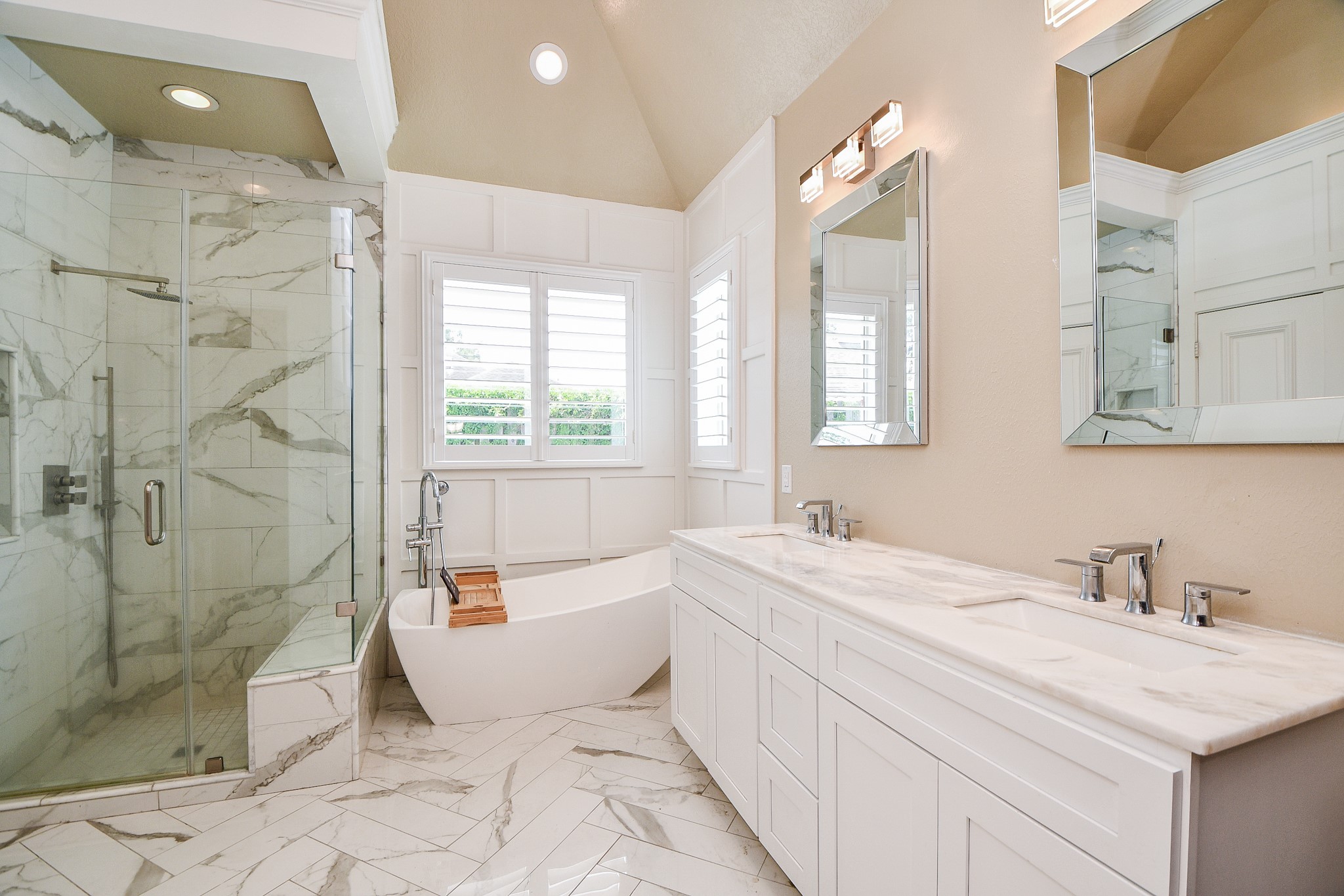 263 Wood Loop Street Houston, TX 77015 - Photo 14 of 45 This bathroom features a luxurious freestanding bathtub, a spacious glass-enclosed shower, and a double-sink vanity with marble countertops. The room is bright and airy, with elegant tile flooring and modern fixtures.