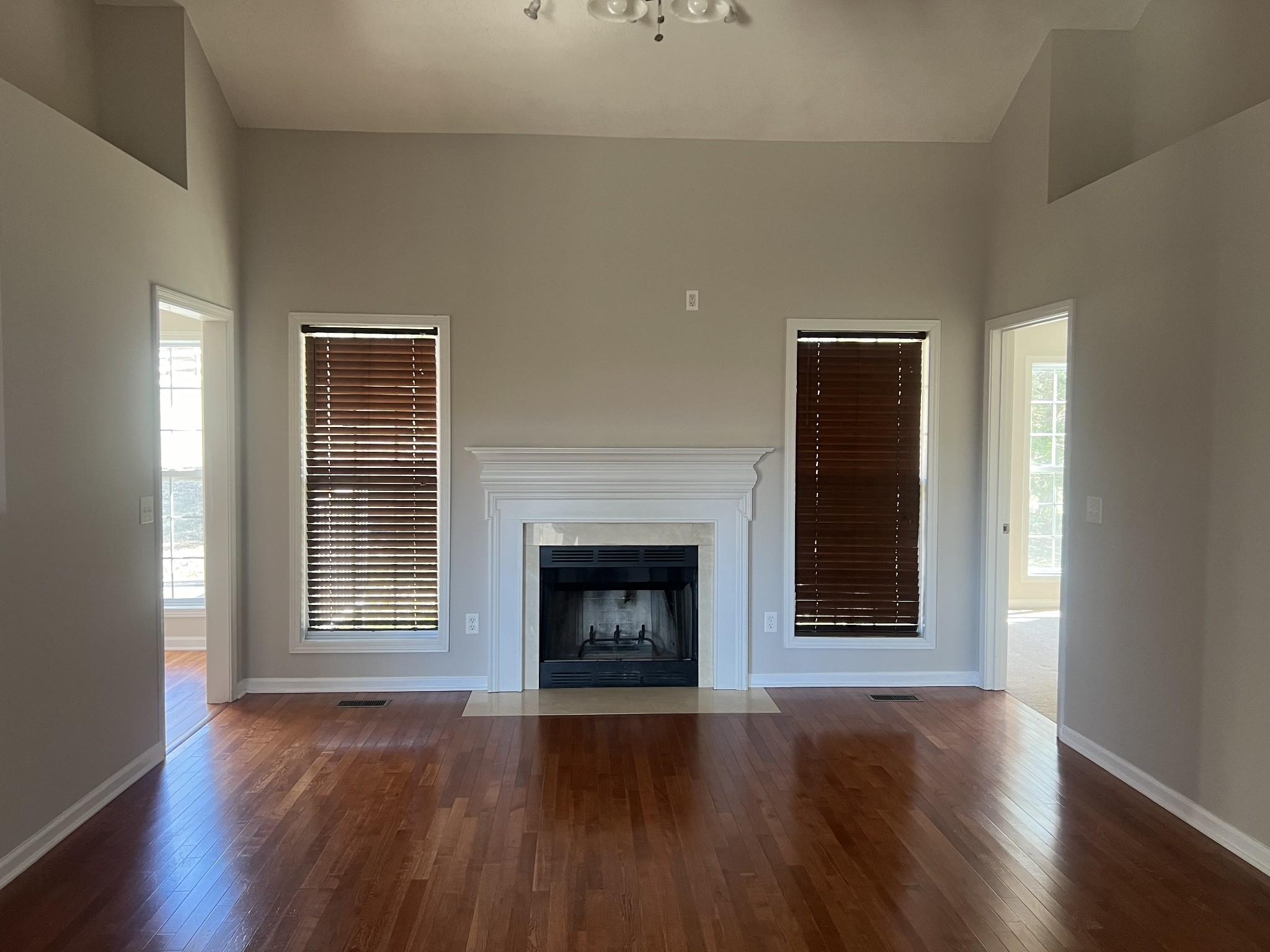 192 Wilkinson Road Cottontown, TN 37048 - Photo 4 of 20 an empty room with wooden floor fireplace and windows