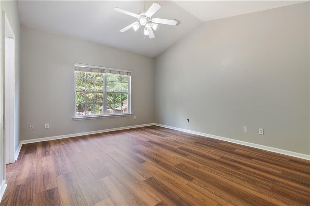 14 Bryan Springs Road Southwest Rome, GA 30165 - Photo 18 of 40 an empty room with wooden floor chandelier fan and windows