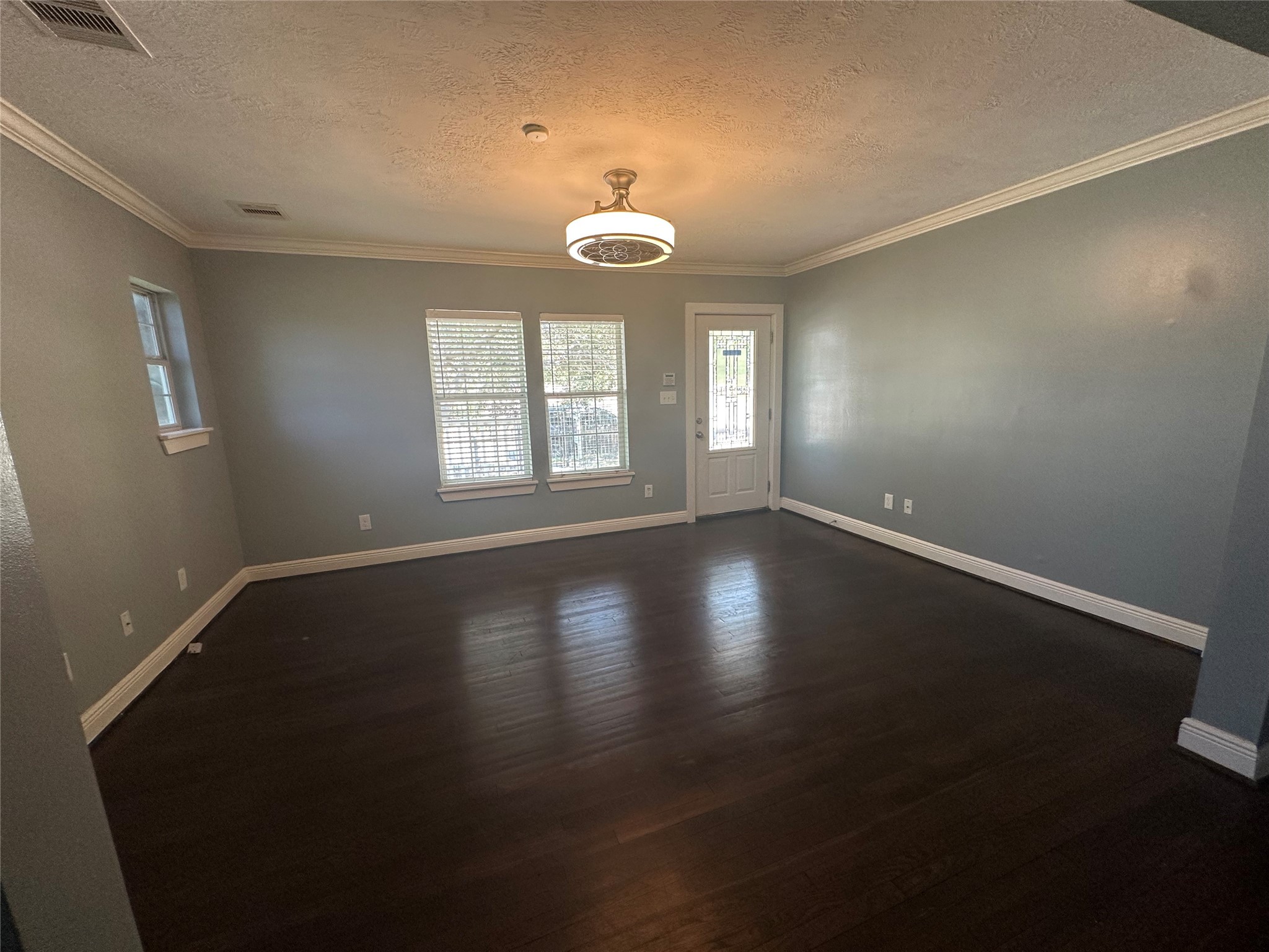 4924 Polk Street Houston, TX 77023 - Photo 3 of 15 an empty room with wooden floor and windows