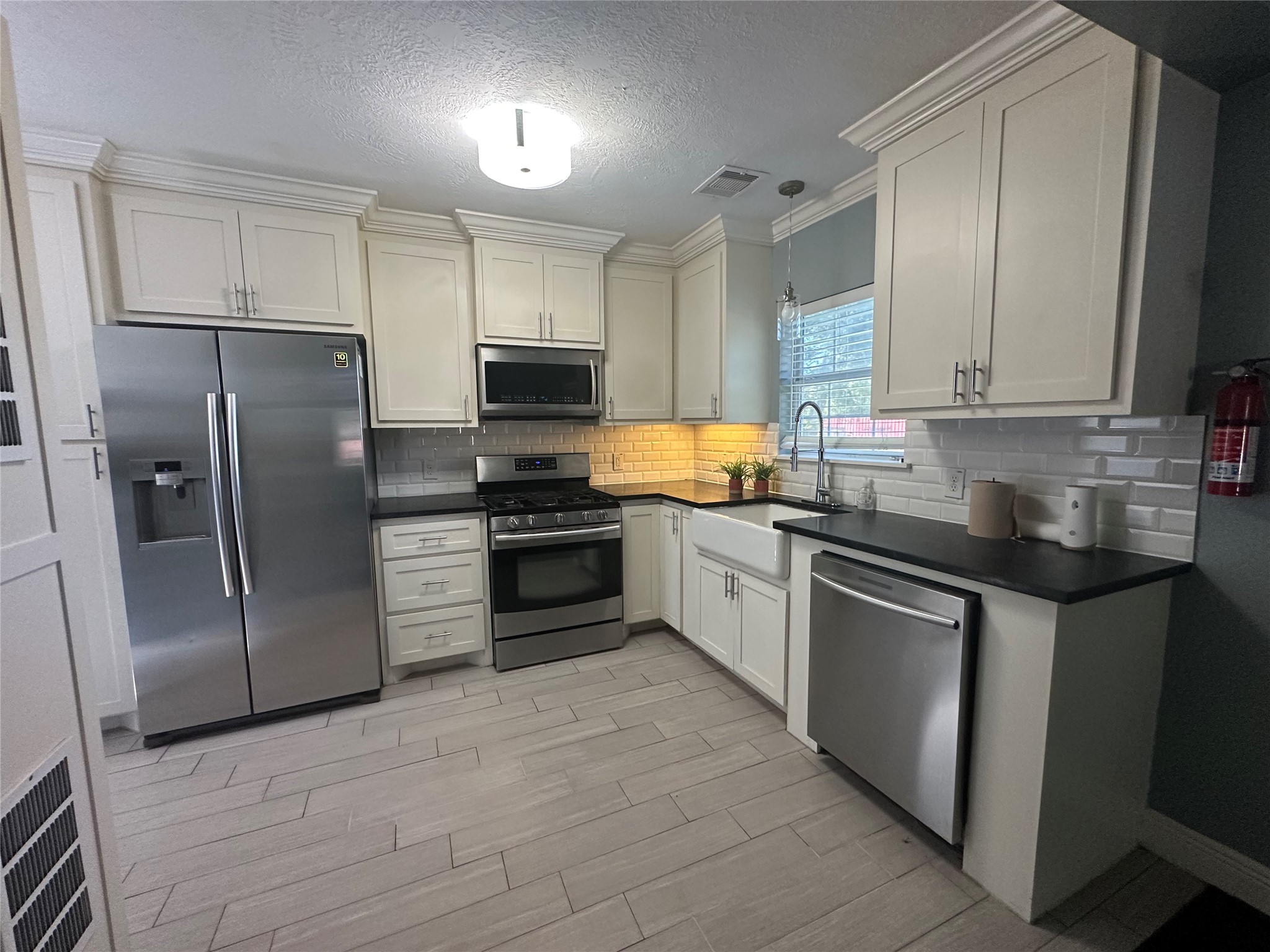 4924 Polk Street Houston, TX 77023 - Photo 5 of 15 a kitchen with stainless steel appliances a refrigerator sink and cabinets