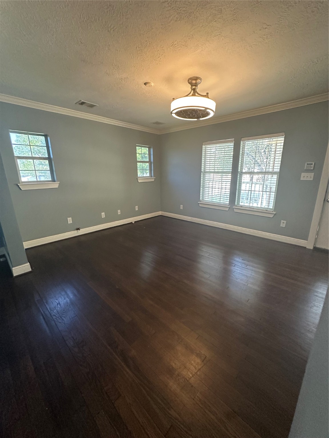 4924 Polk Street Houston, TX 77023 - Photo 7 of 15 an empty room with wooden floor chandelier and window