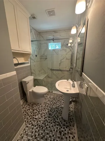 a bathroom with a sink a toilet and shower