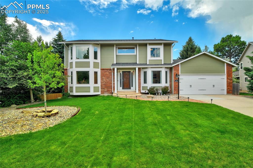 a front view of house with yard and green space