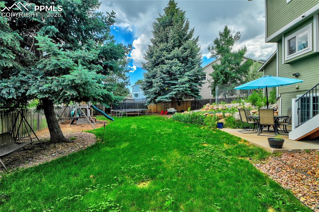 35 Lowick Drive Colorado Springs, CO 80906 - Photo 30 of 32 a view of a backyard with a sitting area and slide