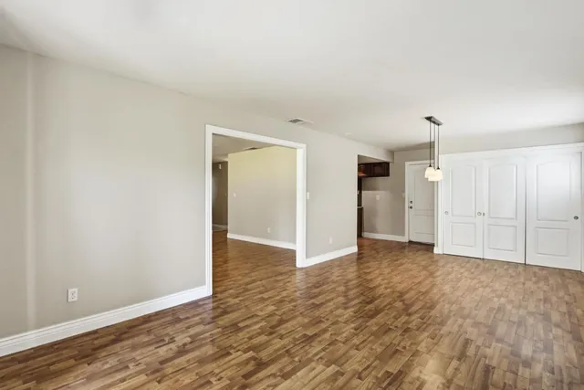 an empty room with windows and fireplace