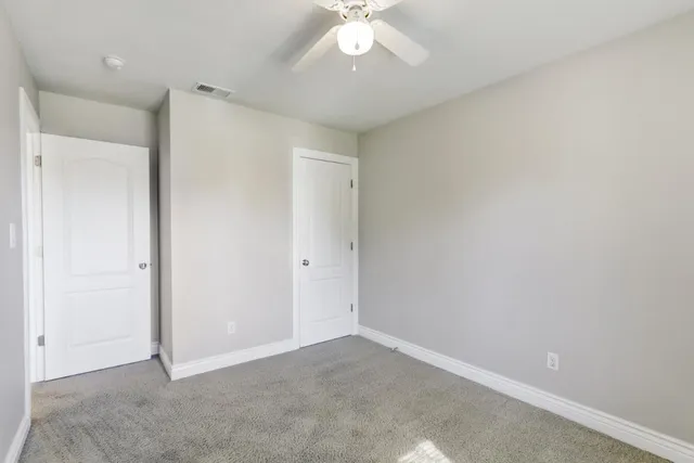 an empty room with a window and a fan