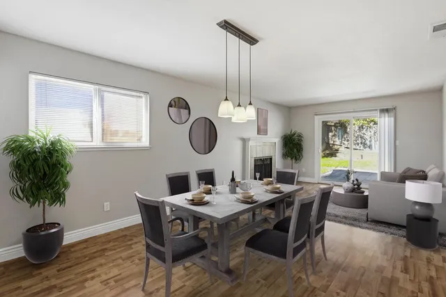 a view of an empty room with wooden floor fireplace and a window