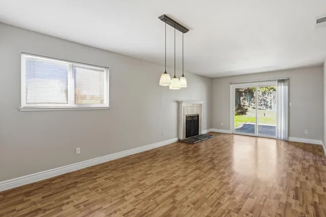 a view of empty room with wooden floor and window
