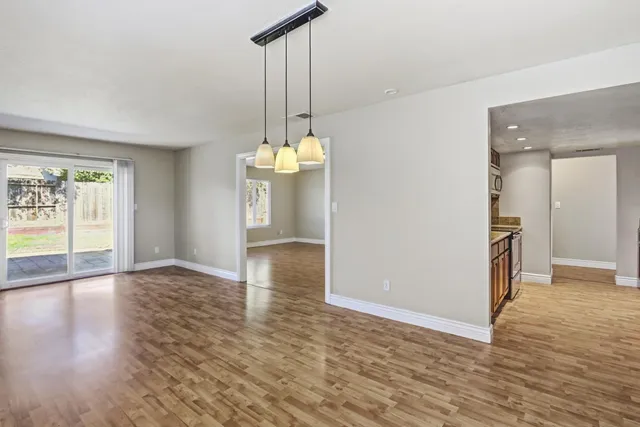 a view of an empty room with wooden floor and cabinet