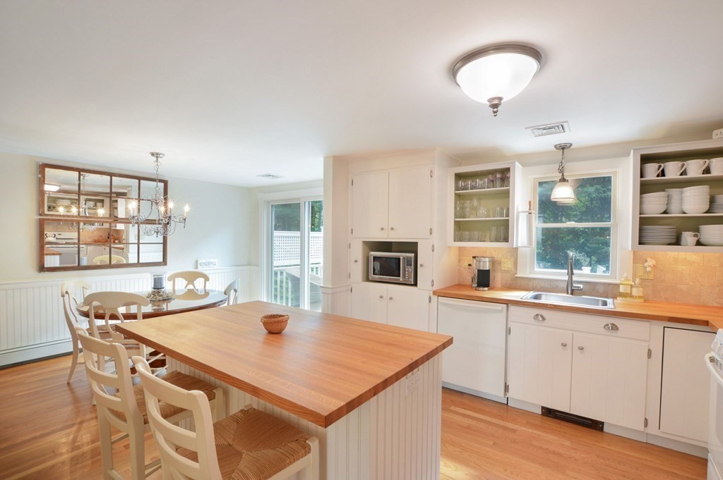89 Emerson Way Barnstable, MA 02632 - Photo 11 of 26 a kitchen with a stove a sink a dining table and chairs