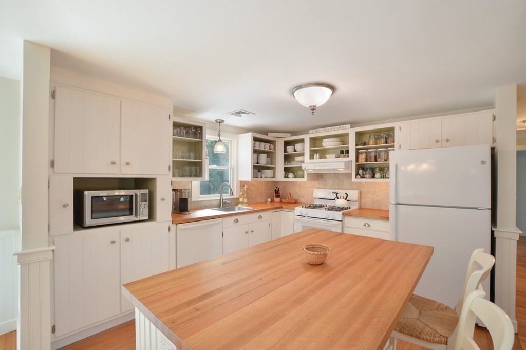 89 Emerson Way Barnstable, MA 02632 - Photo 9 of 26 a kitchen with a refrigerator a stove top oven a sink dishwasher and white cabinets with wooden floor