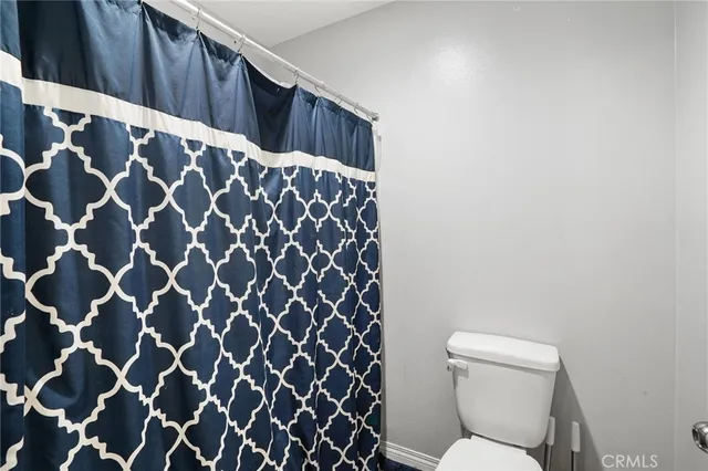 a bathroom with a toilet and a shower curtain