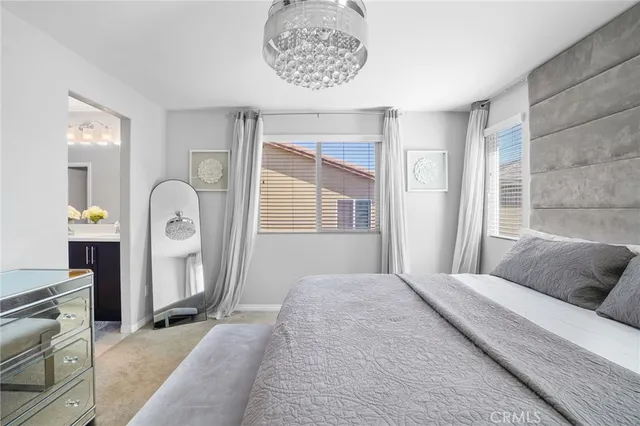 a bedroom with a bed mirror and window