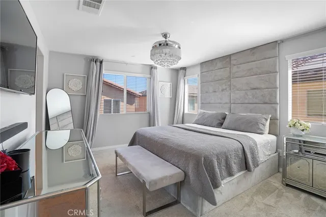 a bedroom with a large bed and windows