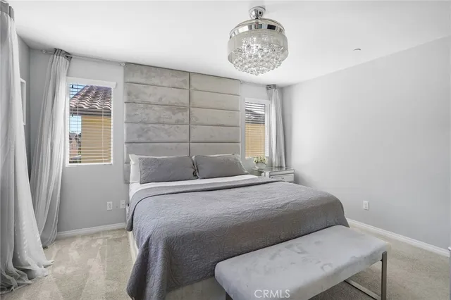 a bedroom with a bed and a chandelier